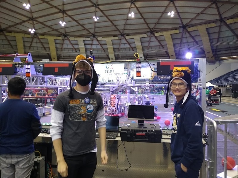Robotics team student standing behind control panel for robot