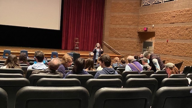 Students seated in auditorium listening to presenter