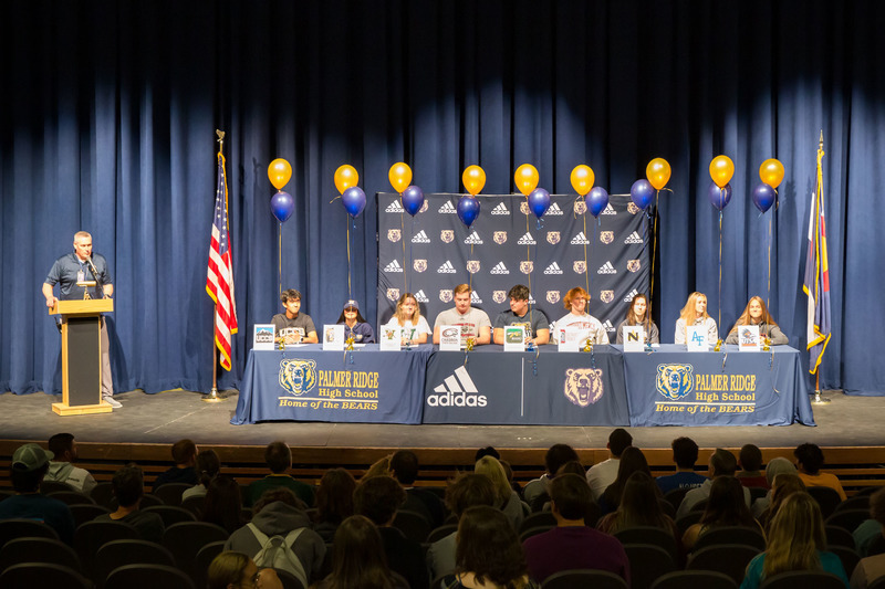 Wide shot of palmer ridge high school students signing collegiate athletic offers