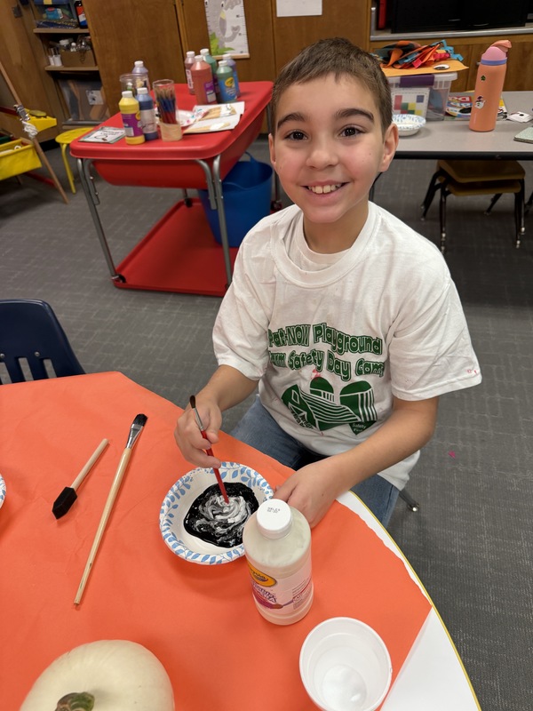 Preschoolers paint pumpkins