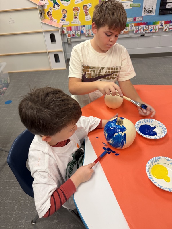 Preschoolers paint pumpkins