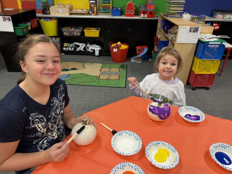 preschoolers paint pumpkins