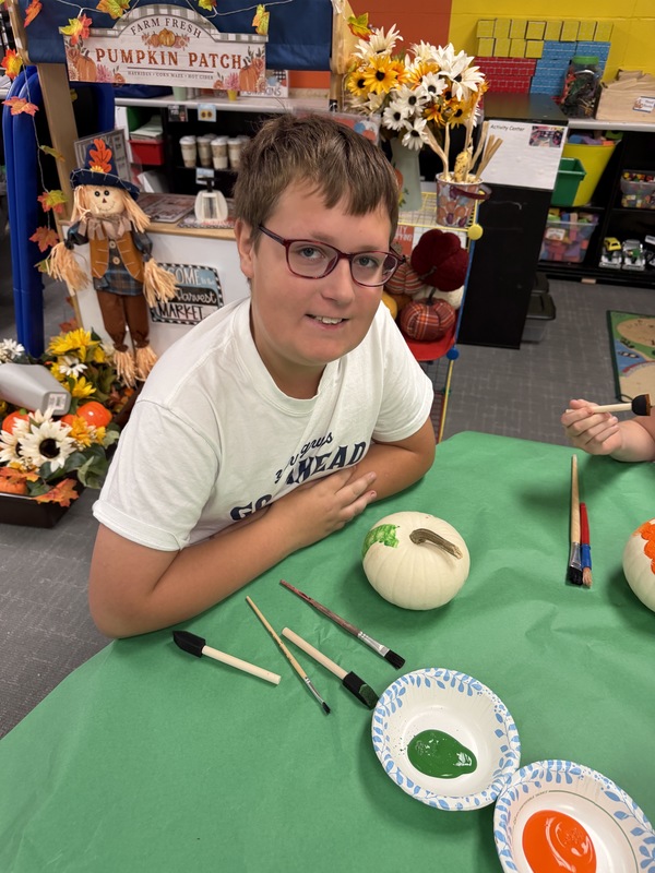 preschoolers paint pumpkins