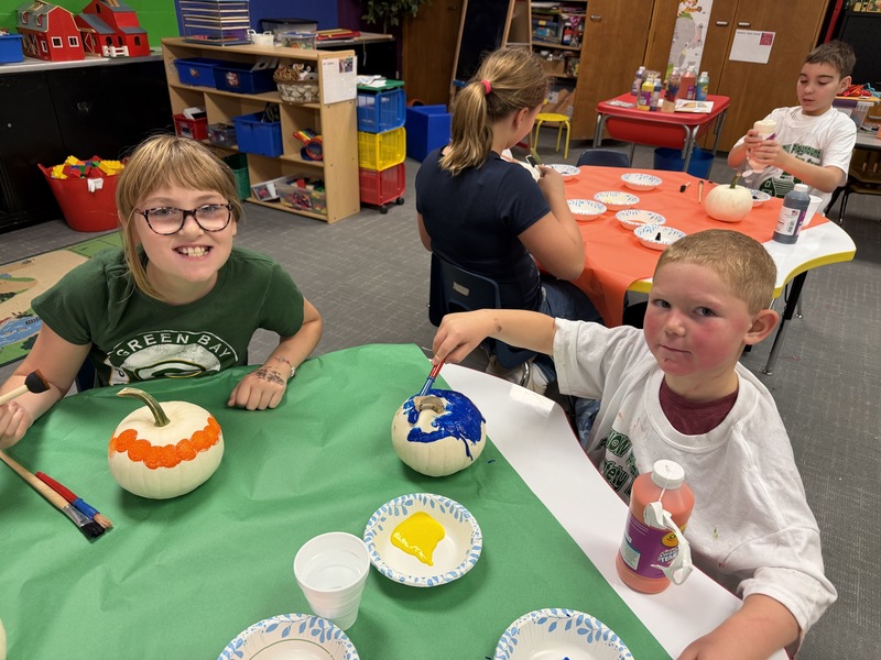 preschoolers paint pumpkins