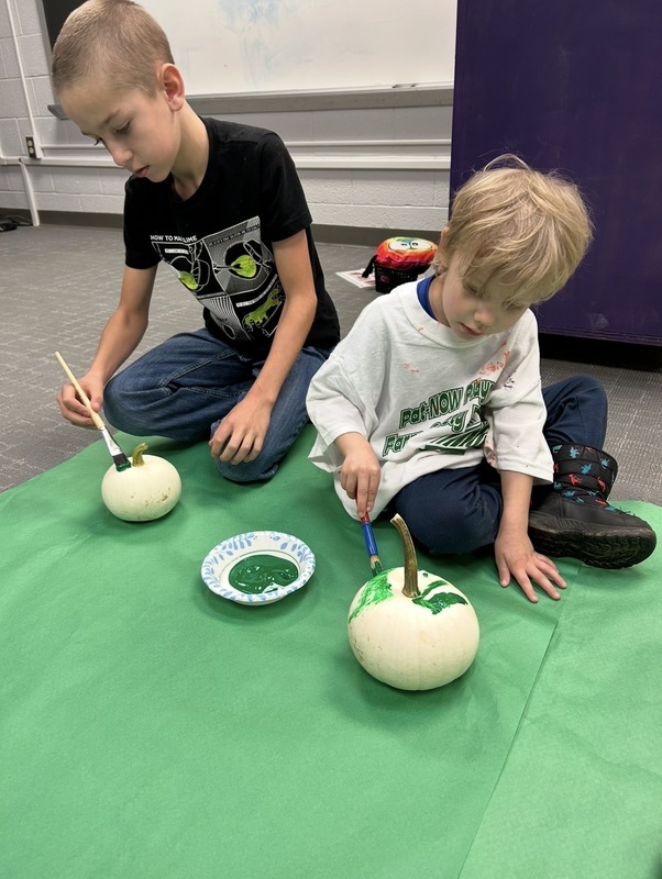 Preschooler and buddy painted pumpkins