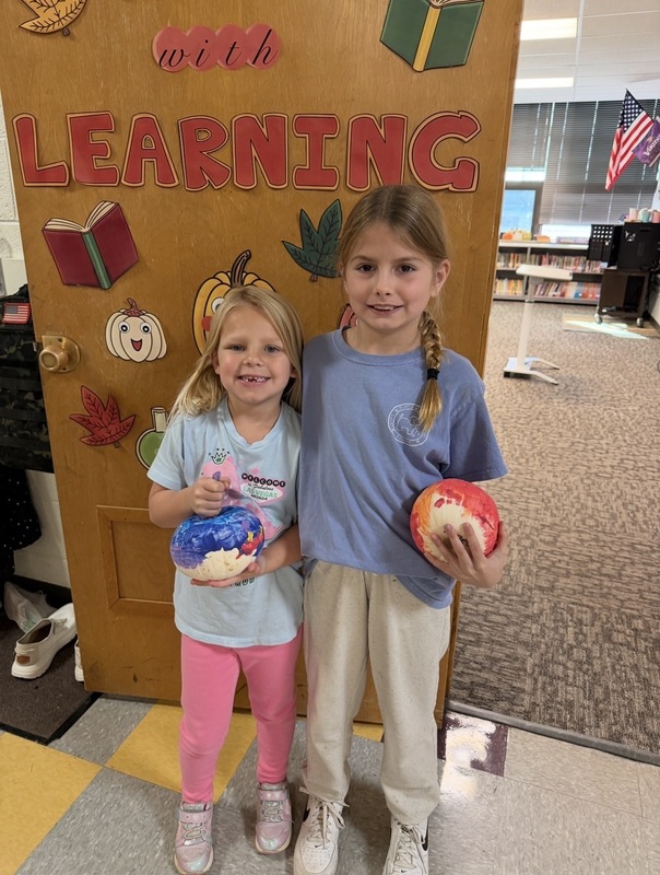 Preschooler and buddy painted pumpkins