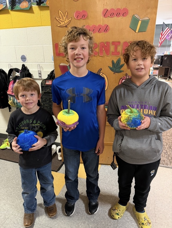 Preschooler and buddy painted pumpkins