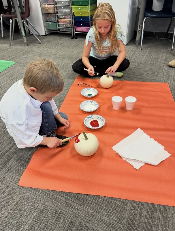Preschooler and buddy painted pumpkins