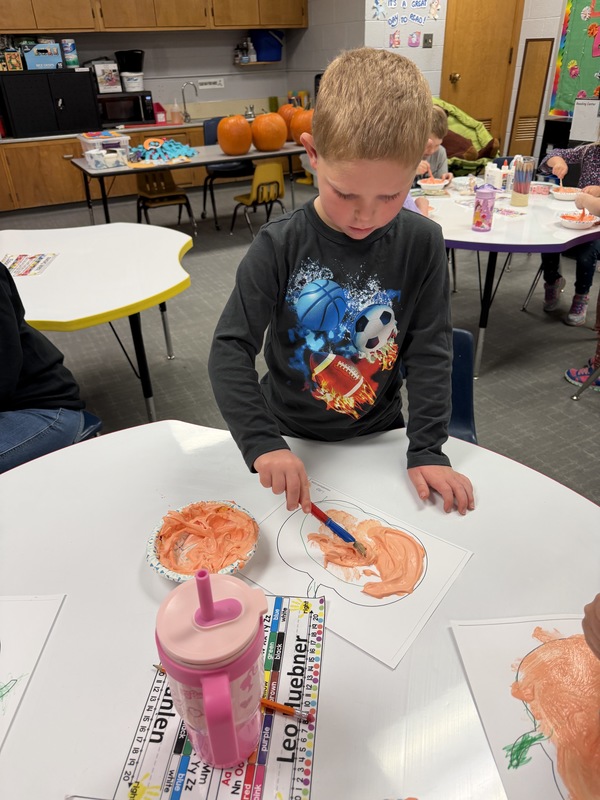 Preschoolers painting pumpkins