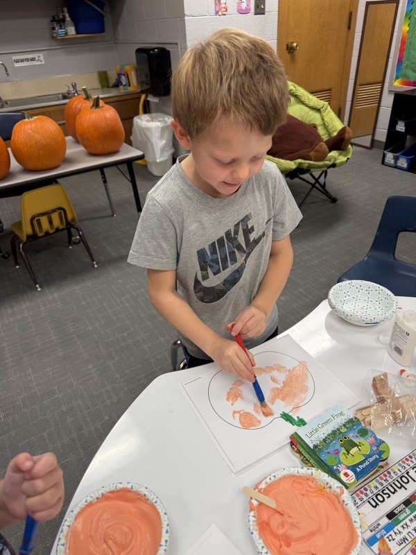 Preschoolers painting pumpkins