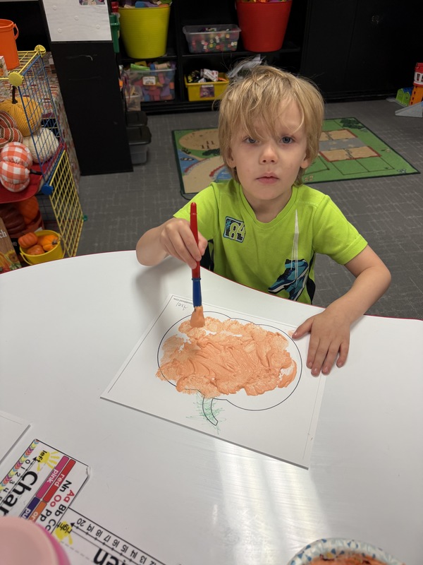 Preschoolers painting pumpkins
