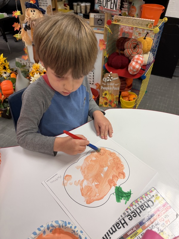 Preschoolers painting pumpkins
