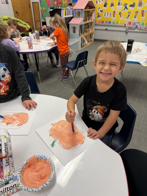 Preschoolers painting pumpkins