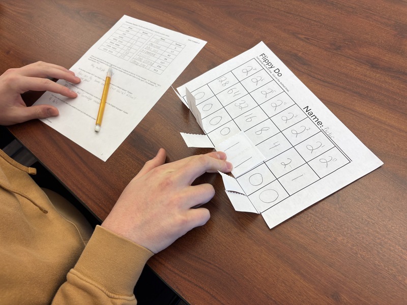 Student converting decimal to binary numbers.