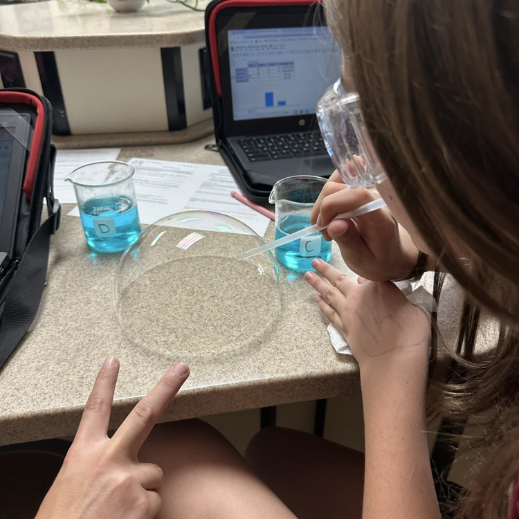 student blowing bubbles during bubble buster lab