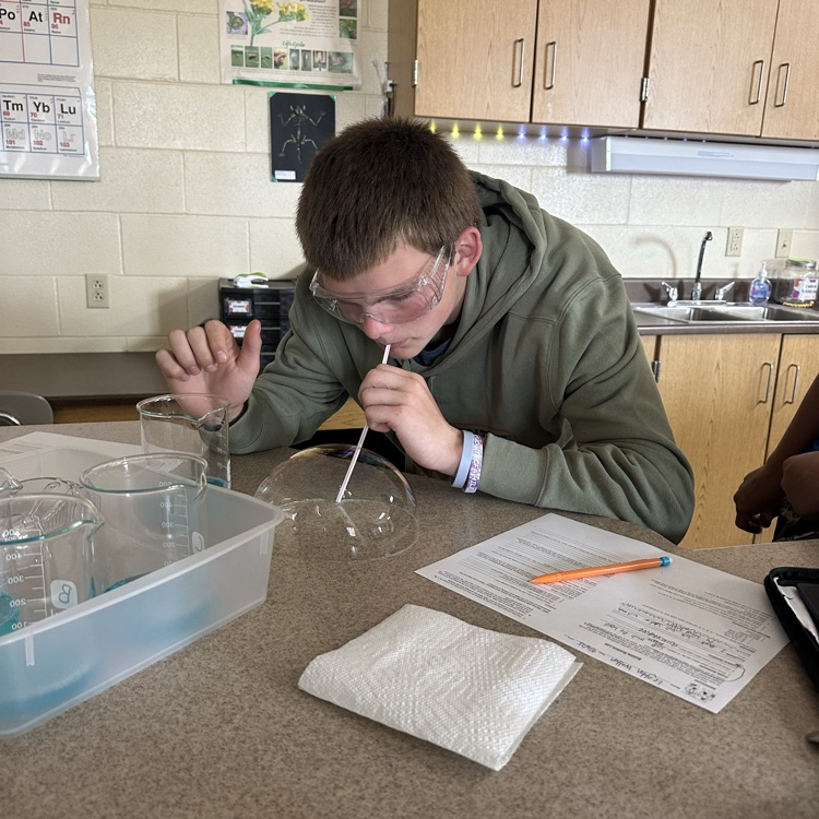 student blowing bubbles during bubble buster lab