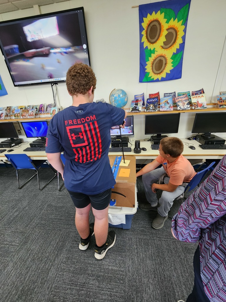 Students attempting to complete a task in a box using grabbers and a webcam