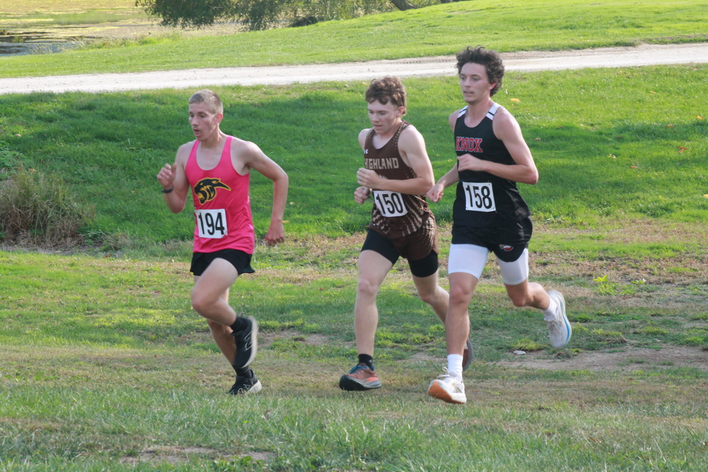 Photo of Nathan Caudill passing Knox County runner and gaining on a Monroe City runner during the Monroe City Invitational.