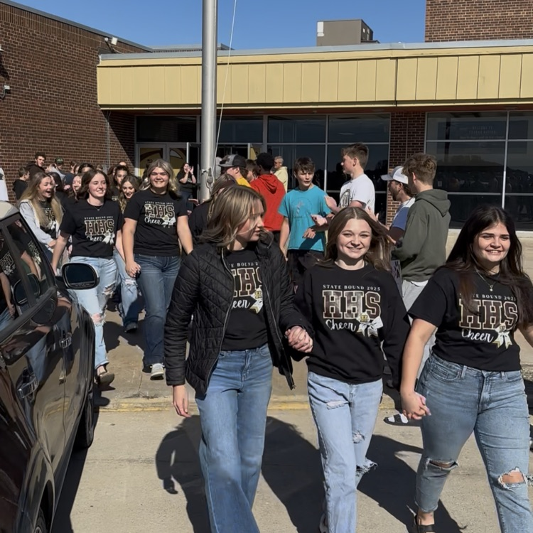 Highland Cheerleaders walking through a tunnel of support as they board the bus to head to the State Competition!