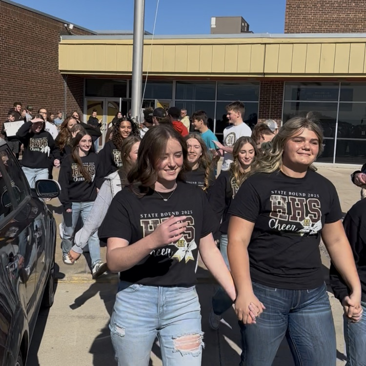 Highland Cheerleaders walking through a tunnel of support as they board the bus to head to the State Competition