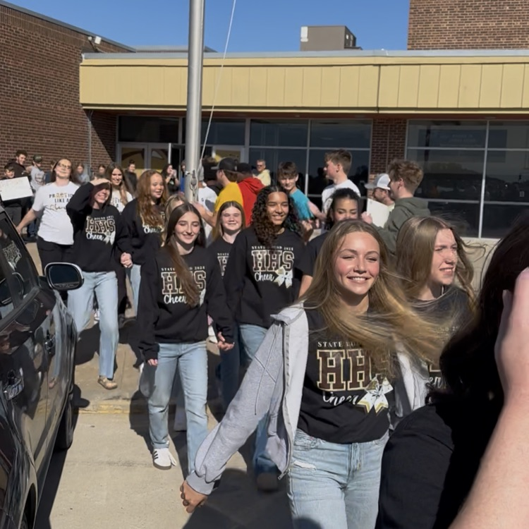Highland Cheerleaders walking through a tunnel of support as they board the bus to head to the State Competition