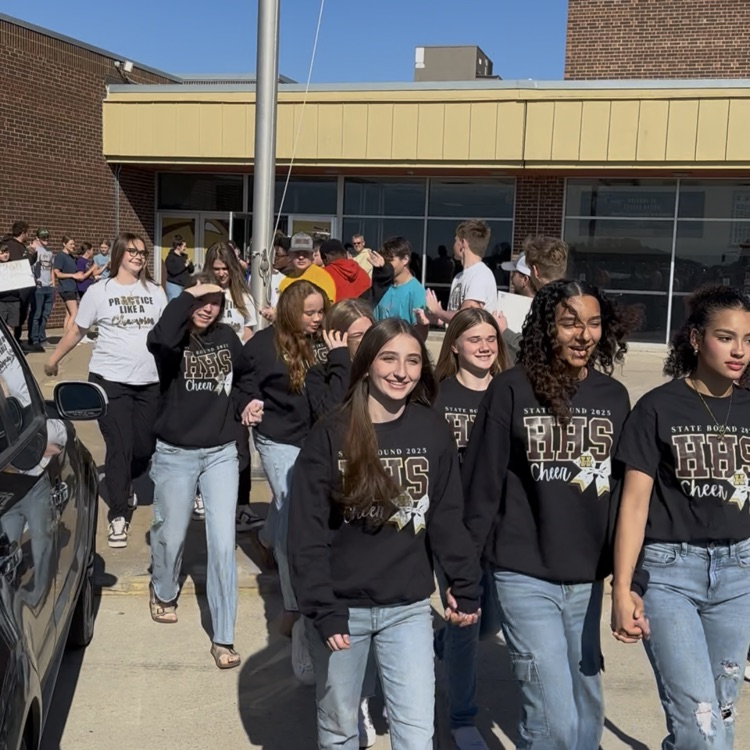 Highland Cheerleaders walking through a tunnel of support as they board the bus to head to the State Competition