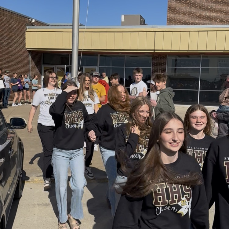Highland Cheerleaders walking through a tunnel of support as they board the bus to head to the State Competition