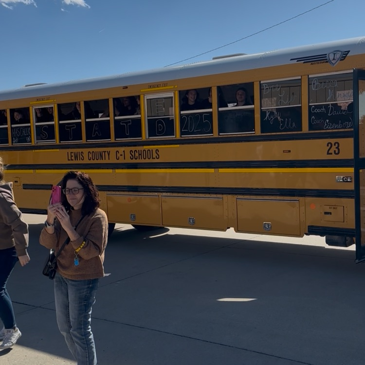 Highland Cheerleaders walking through a tunnel of support as they board the bus to head to the State Competition