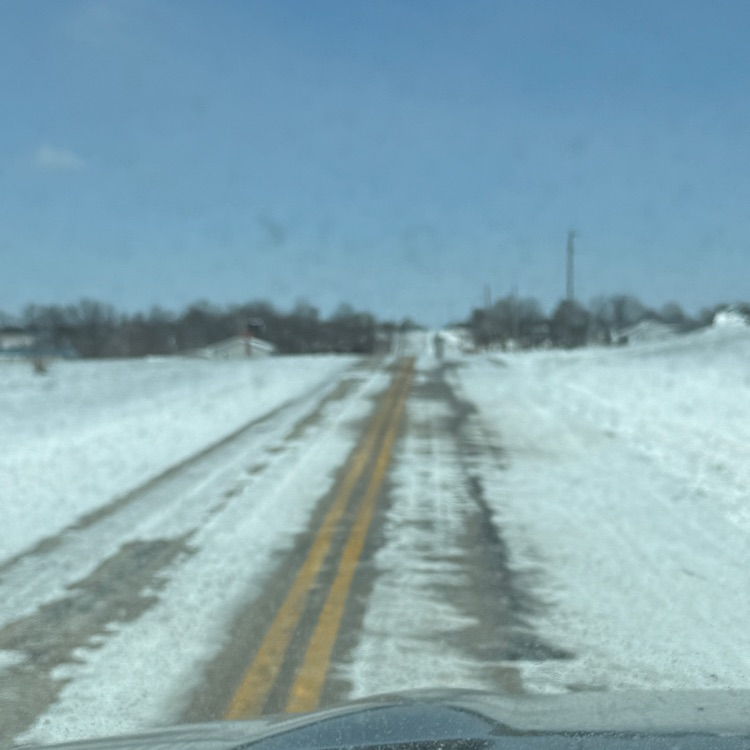 image of a mainly snow covered blacktop road