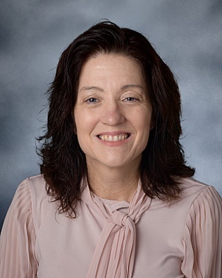 A photo of Dr. Rossmiller in a tan blouse