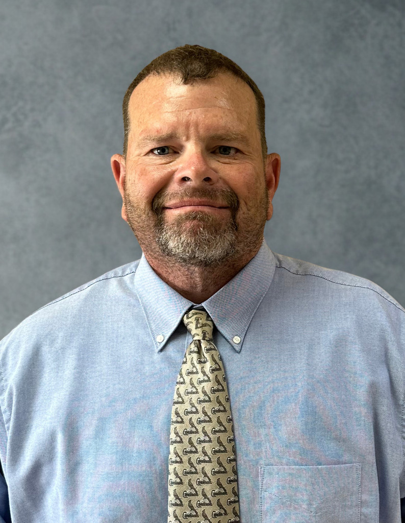 A photo of Mr. Buening in a light blue dress shirt and cardinals tie