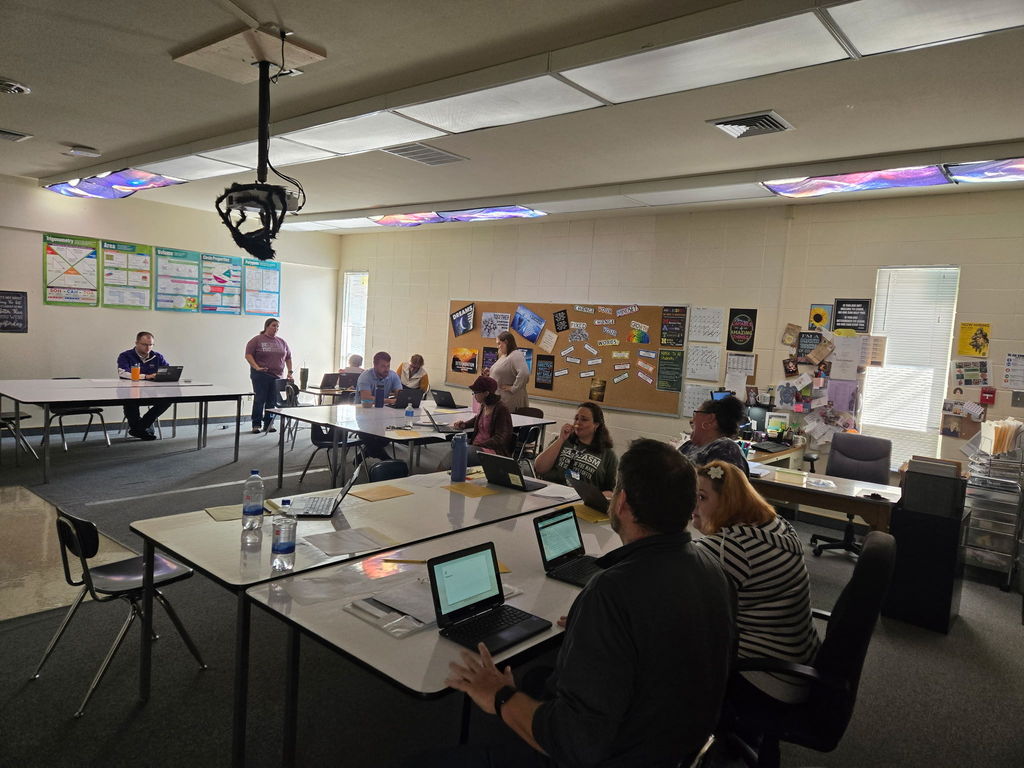 staff working together at desks with laptops