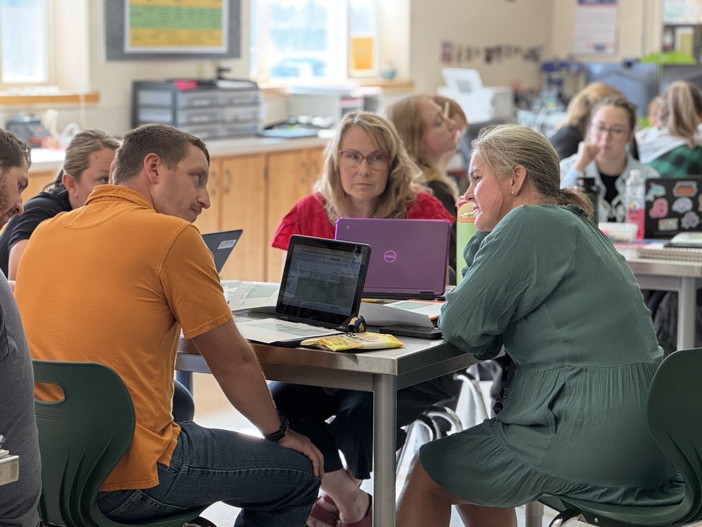 staff working together at desks with laptops