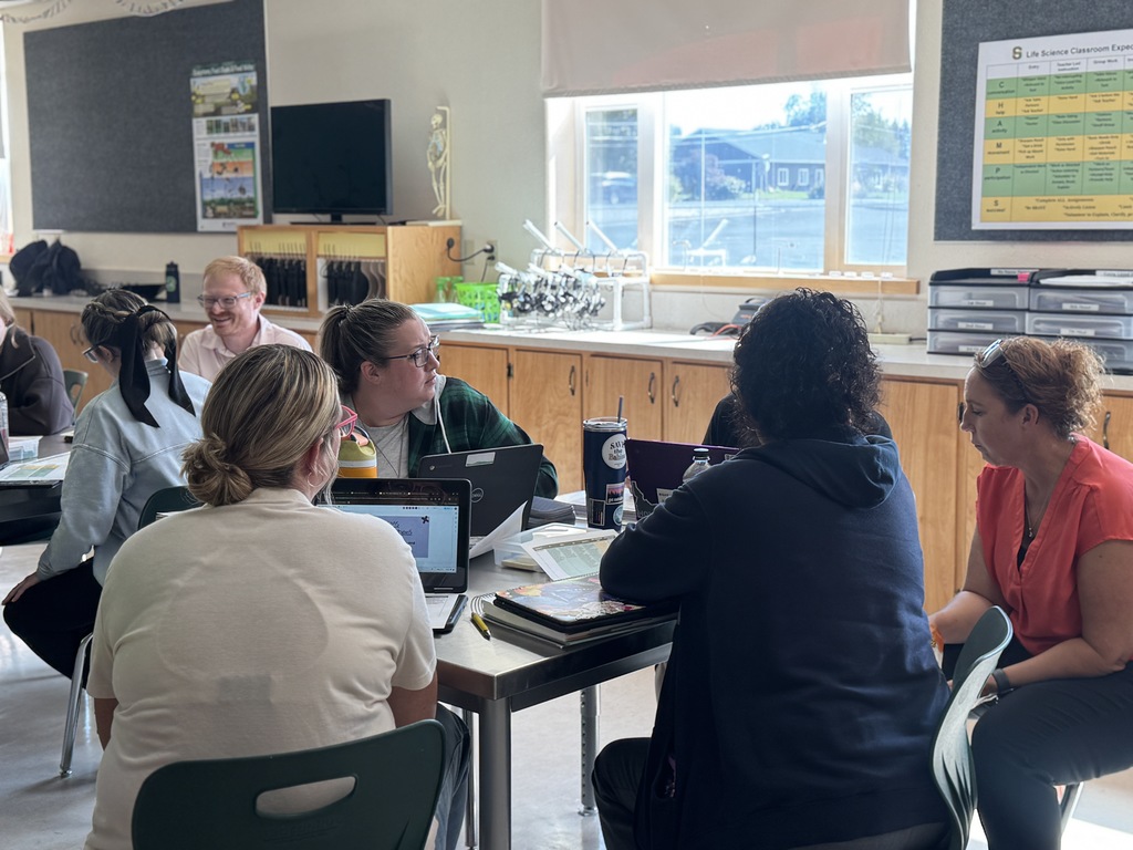staff working together at desks with laptops