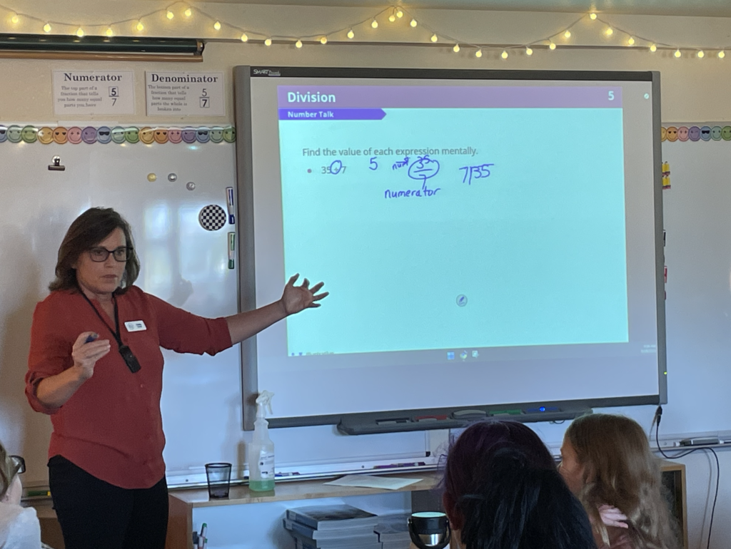 woman in a red shirt with dark hair instructing math