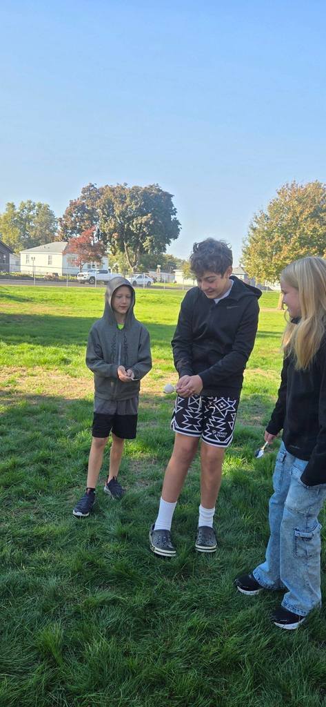 students passing an egg with spoons