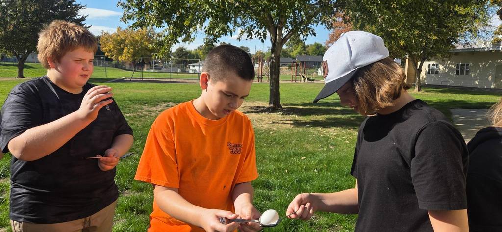 students passing an egg with spoons