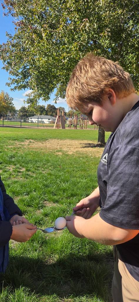 students passing an egg with spoons