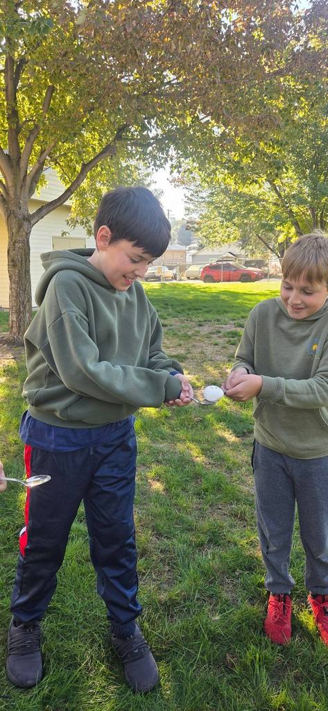 students passing an egg with spoons