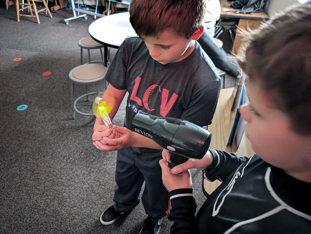 students heating up something with a blow dryer