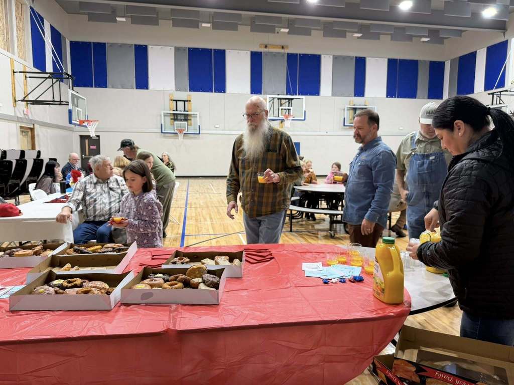 students eating donuts with veterans