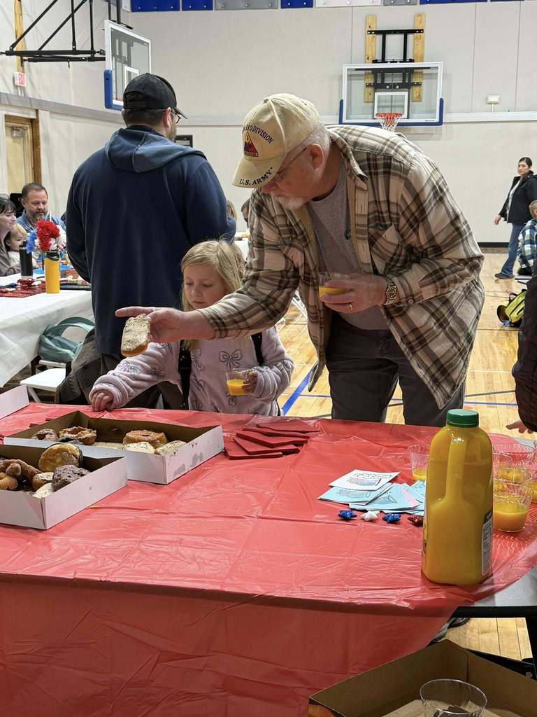 students eating donuts with veterans