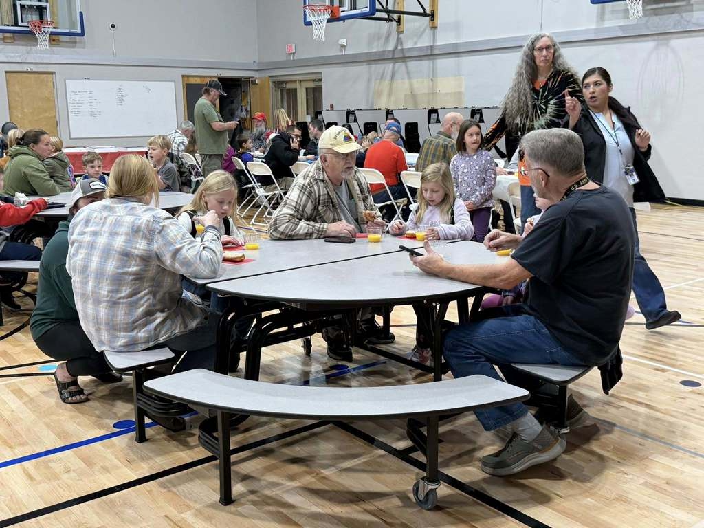 students eating donuts with veterans