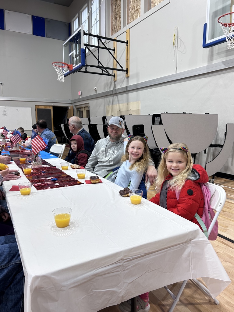 students eating donuts with veterans