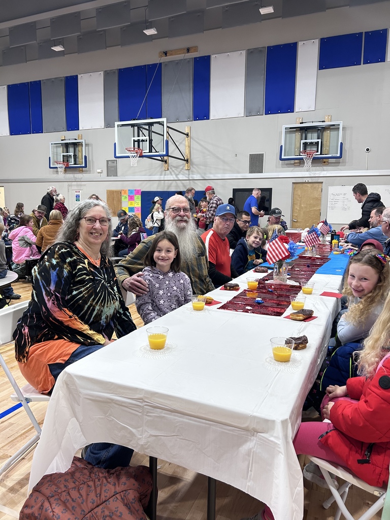 students eating donuts with veterans