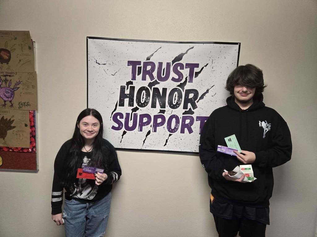 a female and male student holding gift cards