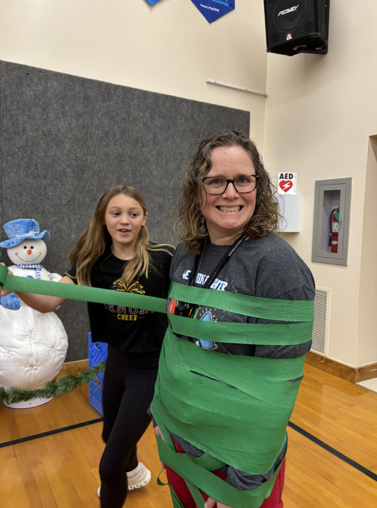 students dressing their teachers up like Christmas trees