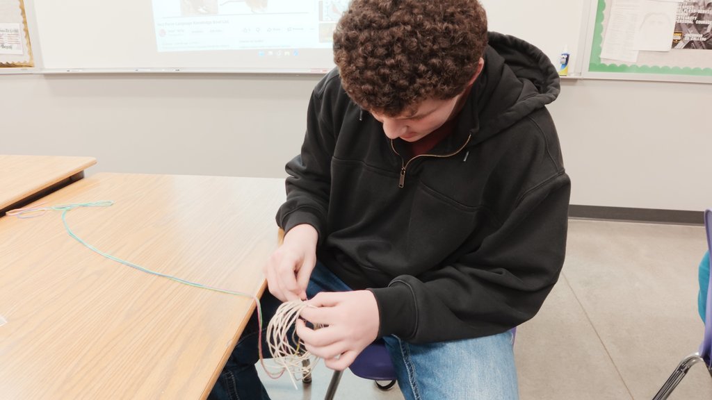 students learning to weave