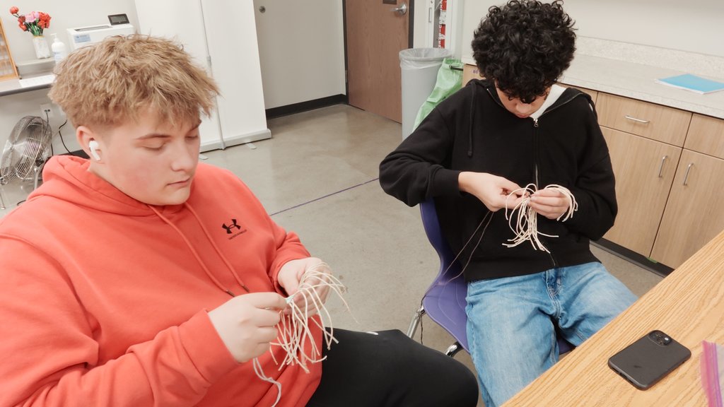 students learning to weave
