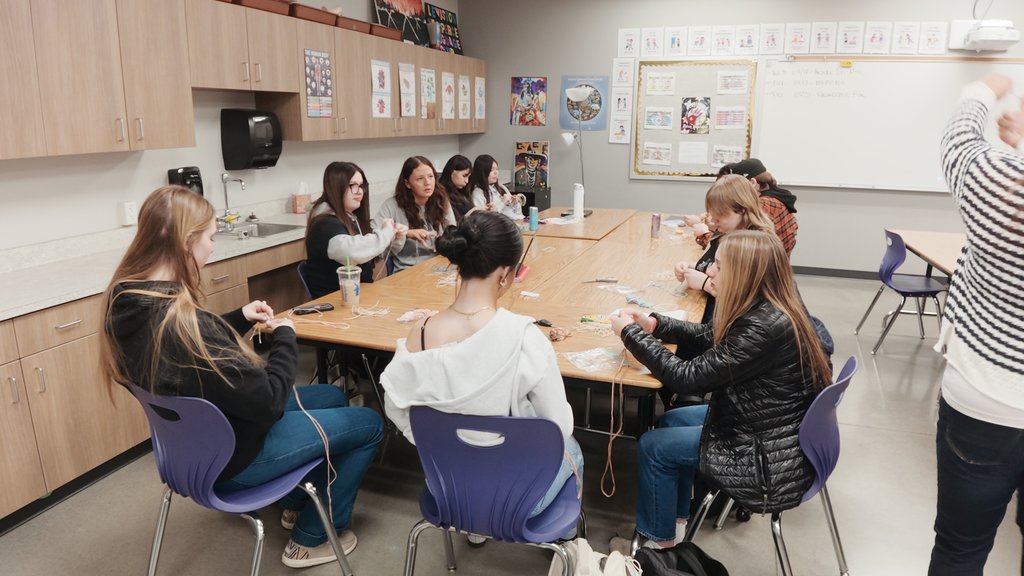 students learning to weave